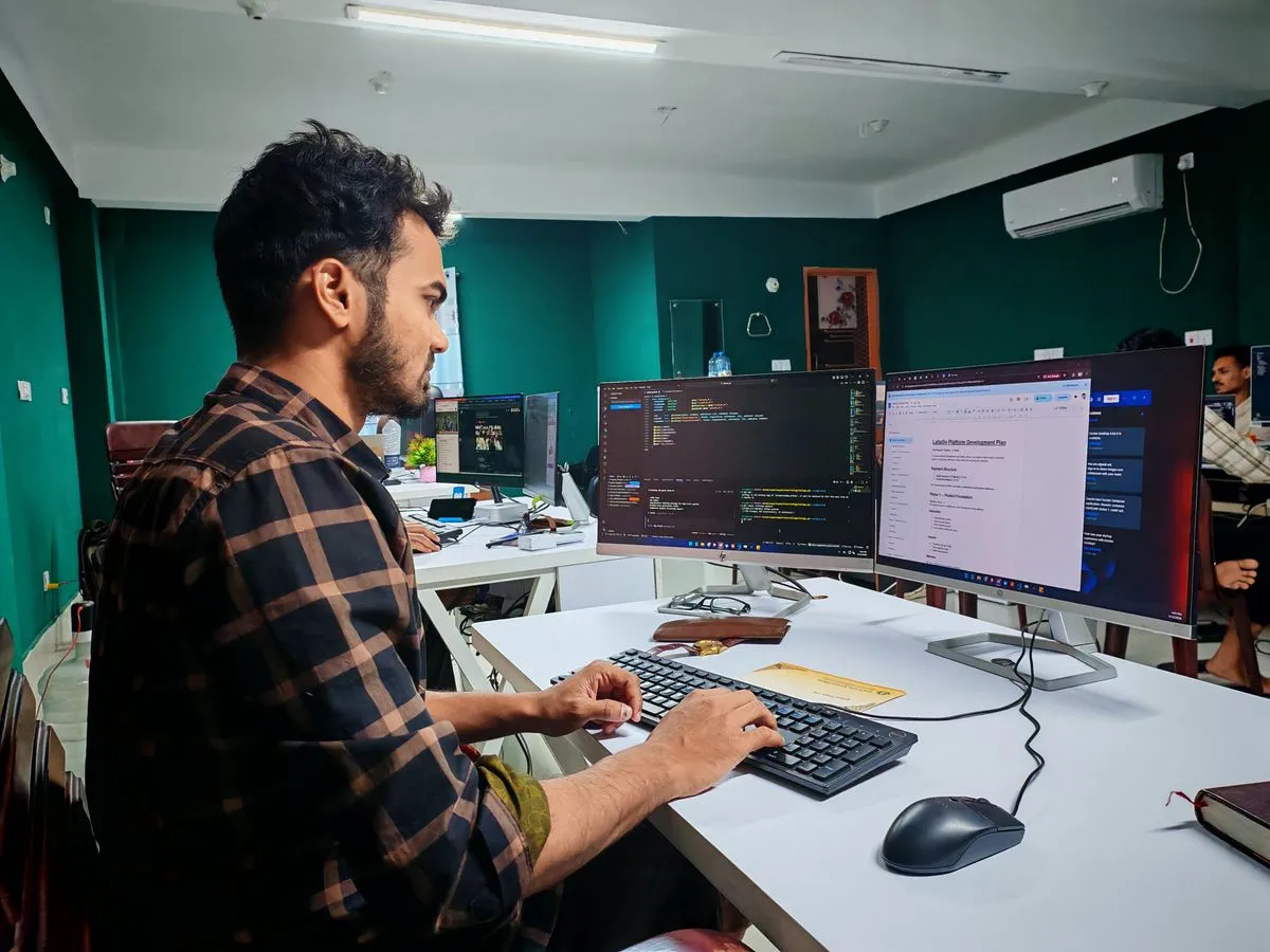 Desarrollador trabajando con dos monitores en una oficina moderna